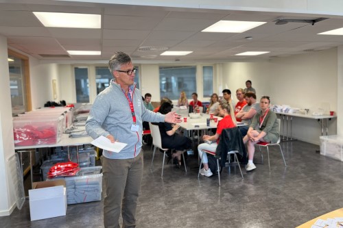 Ombud Bjørn Erik Thon står foran en gruppe sittende mennesker i et møterom og holder en presentasjon, med fokus på å gi informasjon eller instruksjoner. Foto