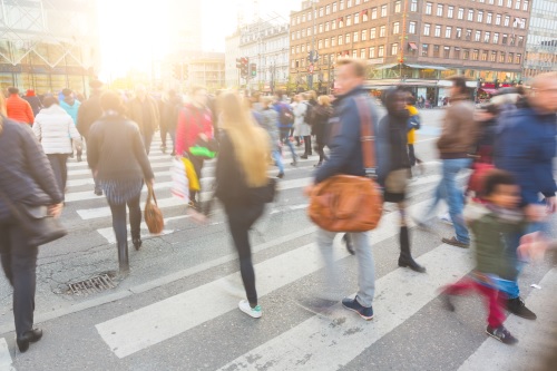 Uskarpt bilde av en mengde mennesker som går på sebraovergang i København sent på ettermiddagen. Noen av dem har også med seg sykkel, typisk transportmiddel i byen. Foto