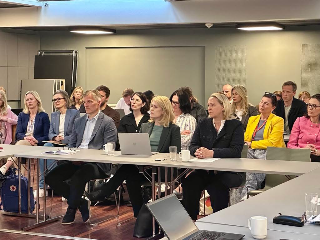 Representanter for amerikanskeide selskaper i Norge slik som Microsoft Accenture og McDonalnds sitter rundt et bord. Bak dem sitter flere fra de samme selskapene. Foto