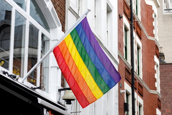 Prideflagg som henger på en vegg utendørs