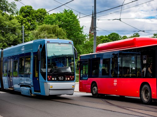 Bilde av en blå trikk og en rød buss i Oslo