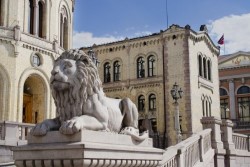 Skulptur av en løve med Stortinget i bakgrunnen